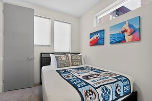 A bedroom with a bed, two windows, a door, and two wall-mounted paintings. - Stunning water view, pet friendly, luxury 3-bedroom townhome with AC in Seattle (Seattle)