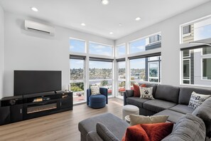 Una sala de estar moderna con un televisor de pantalla plana, un sofá y una mesa de centro.