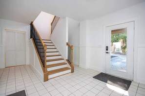 A staircase with wooden steps and black railings leading to a landing.