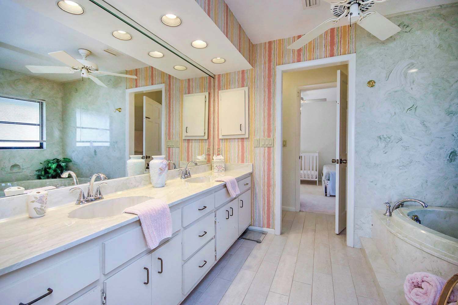 A bathroom with a large vanity, a bathtub, and a shower area.