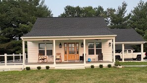 A two-story house with a covered porch, a front door, and a garage.