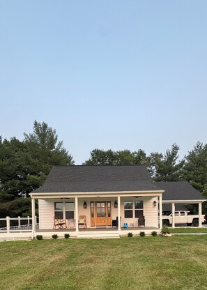 A two-story house with a covered porch, a front door, and a garage.
