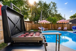 A barbecue grill with meat, a swimming pool, and lounge chairs. - Heated Pool • Golf • Fire Pit • 15 Min To Beach (Seminole)