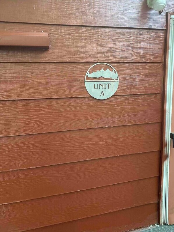 A wooden door with a circular sign that reads 'UNIT A'.