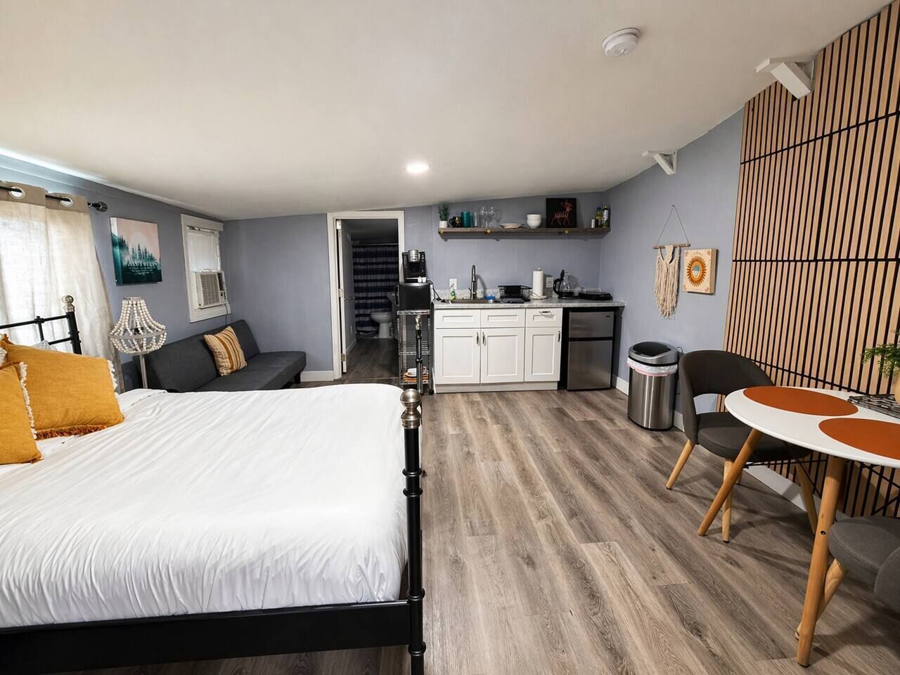 Une chambre à coucher comprenant un lit, une table de chevet, une chaise et une petite table avec une chaise.