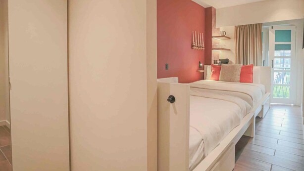 A bedroom with a bed, a wardrobe, and a door leading to a balcony. - Casa Mexico (Ciudad de México)