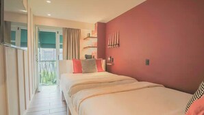 A hotel room with a bed, a window with curtains, a small table with a lamp, and a wall-mounted light fixture. - Casa Mexico (Ciudad de México)