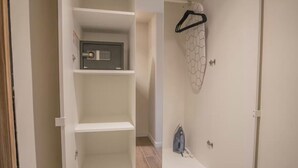 A walk-in closet with a safe, a hanging rack, and an ironing board. - Casa Mexico (Ciudad de México)