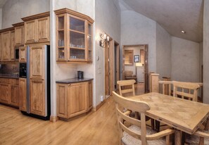 Eine geräumige Küche mit Holzschränken und einem Essbereich mit Holztisch und -stühlen.