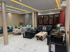 A modern living room with a sofa set, a coffee table, and a television.