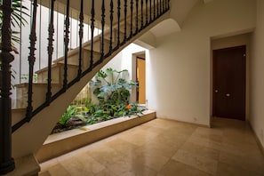 Eine Treppe mit schwarzer Geländer, die zu einer Zwischenebene mit Gartenbereich führt.