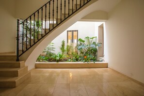 Eine Treppe führt zu einer Aussichtsplattform mit Blick auf eine Gartenanlage.