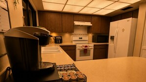 Una cocina con cafetera, microondas y refrigerador.