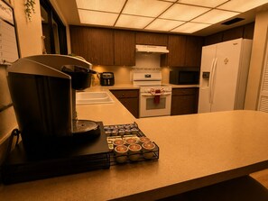 Una cucina con macchina del caffè, forno a microonde e frigorifero.