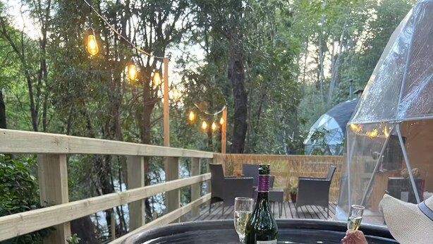 A hot tub with a bottle of wine and a glass on a wooden deck. - Domos Palguin (Palguin Alto)