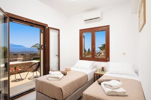 A hotel room with two beds, a balcony, and a view of the landscape. - Peaceful Luxury Villa with Private Pool See View and Mountain View (Χανιά)
