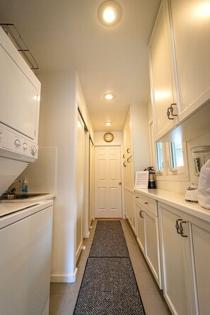 A narrow kitchen with white cabinets, a built-in oven, and a window. - 10-Min Walk to Downtown & Lake • 10-Min Drive to Schweitzer Base (Sandpoint)