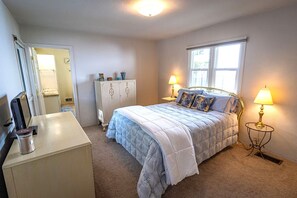 A bedroom with a bed, bedside lamps, a dresser, a wardrobe, and a window. - 10-Min Walk to Downtown & Lake • 10-Min Drive to Schweitzer Base (Sandpoint)
