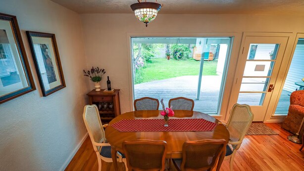 A dining area with a wooden table, six chairs, and a decorative rug. - 10-Min Walk to Downtown & Lake • 10-Min Drive to Schweitzer Base (Sandpoint)