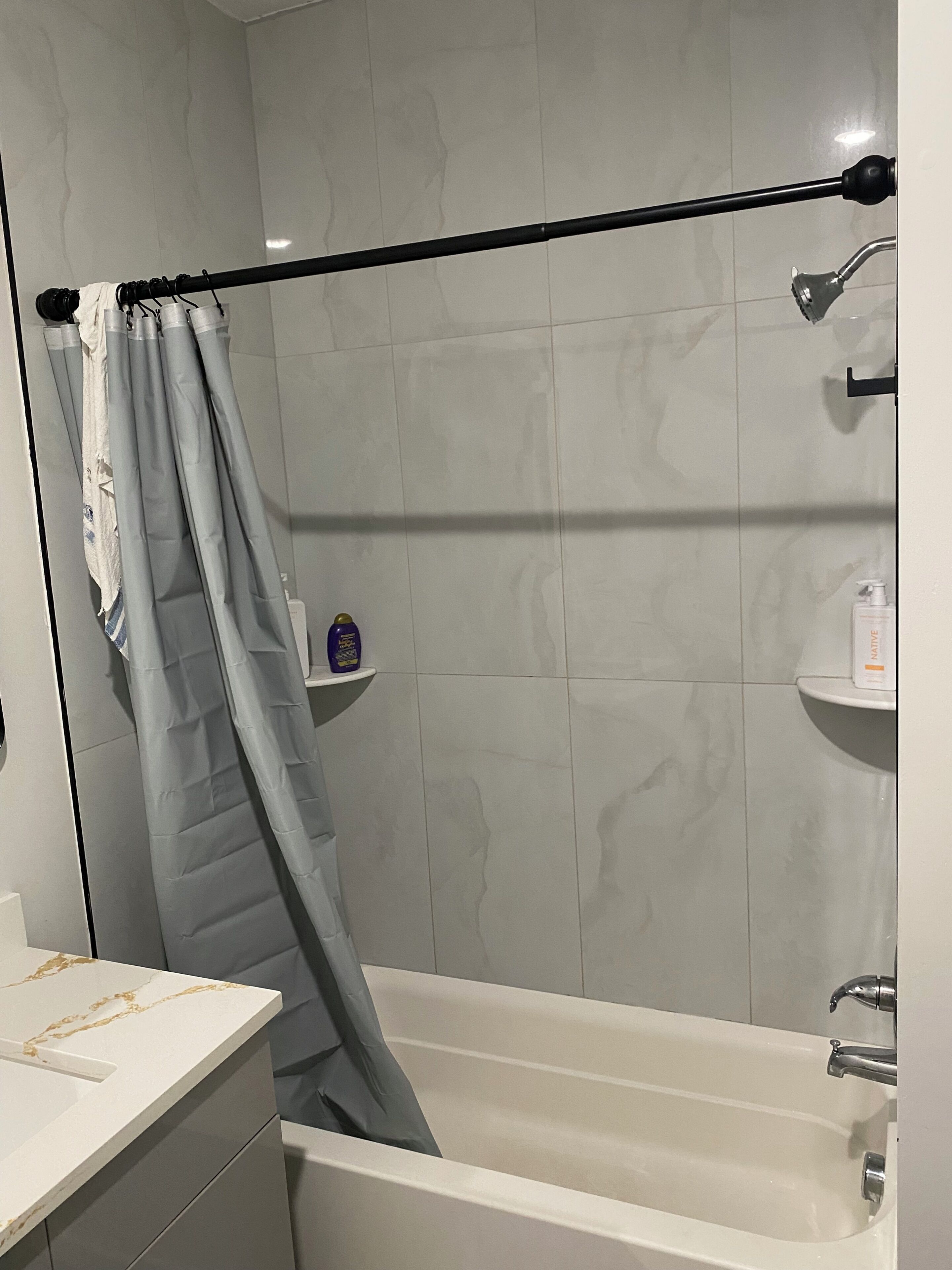 Ein Badezimmer mit einer Badewanne, einer Duschvorhang und einem Handtuchhalter.