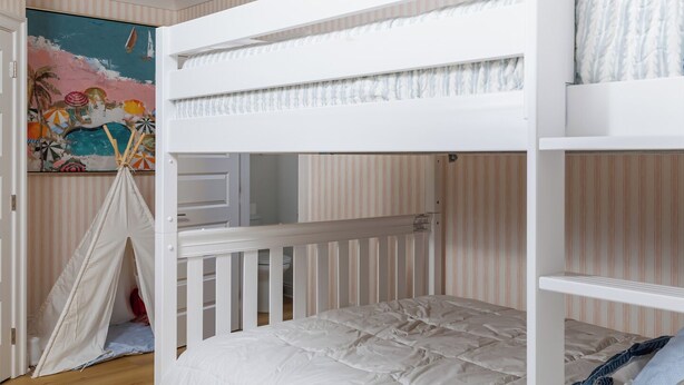 A bunk bed with a white finish, a small shelf unit, and a wall-mounted ceiling light fixture. - New Stunning Luxury Beach Home with Private Pool! (Pensacola Beach)