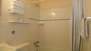 Une salle de bain avec des toilettes, un lavabo et une baignoire.