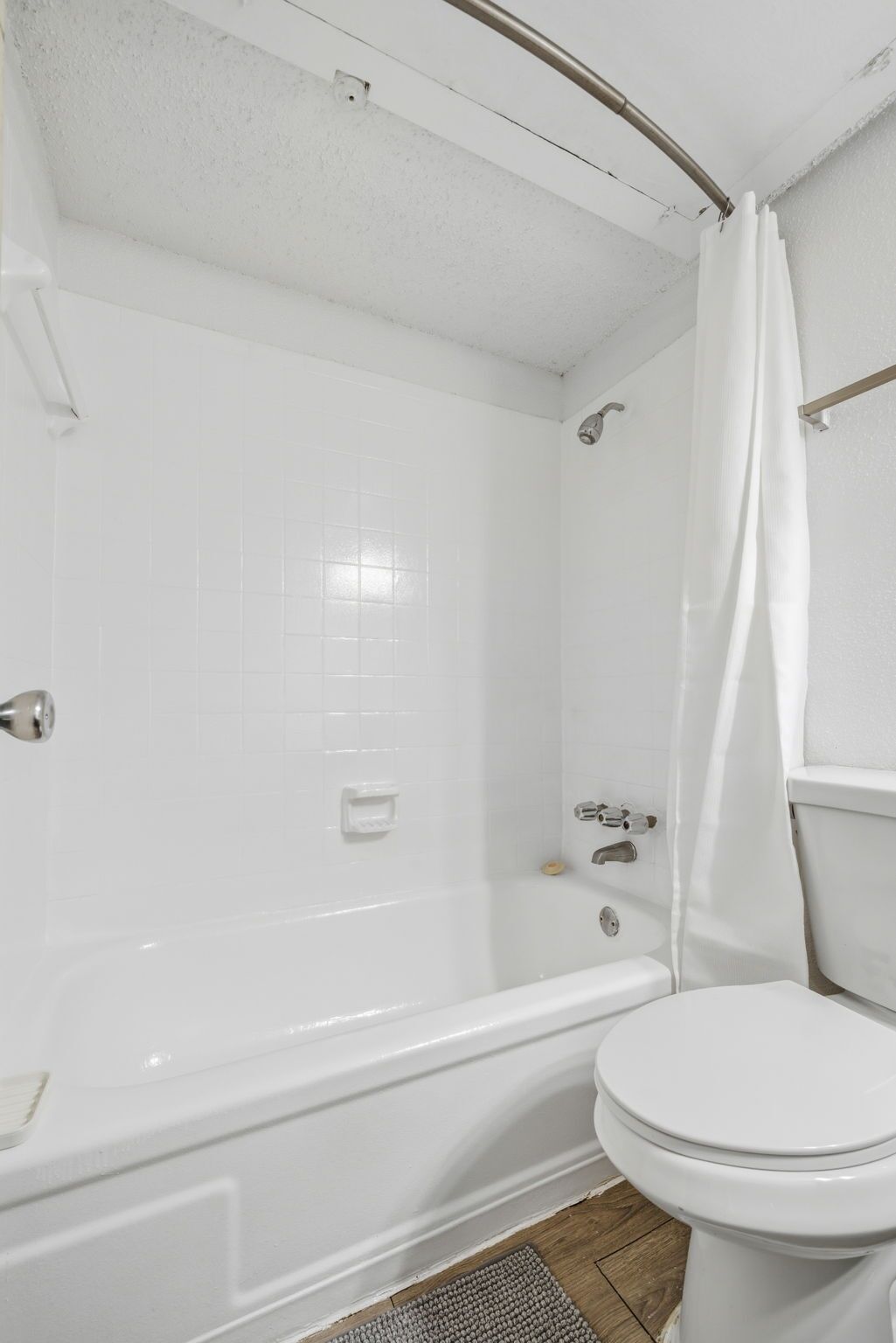 Une salle de bain avec une baignoire, des toilettes et un rideau de douche.