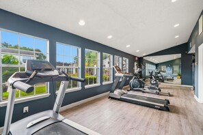 A gym with treadmills, exercise bikes, and a mirrored wall. - 1307-Wilcrest-4201 (Houston)