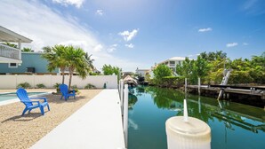 Uma piscina com um canal estreito, uma cadeira azul e uma estrutura branca.