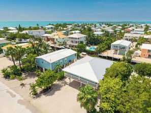 A coastal residential area with houses, a swimming pool, and boats.