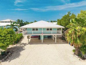 A two-story building with a covered porch and a small attached structure.
