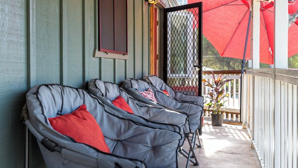A row of reclining chairs with red cushions on a covered porch with a metal railing. - General Sherman Loft ~ 2 min from Sequoia Nat’l Park (Three Rivers)