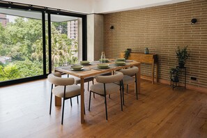 Un comedor con una mesa de madera, cuatro sillas y una pared de ladrillo.