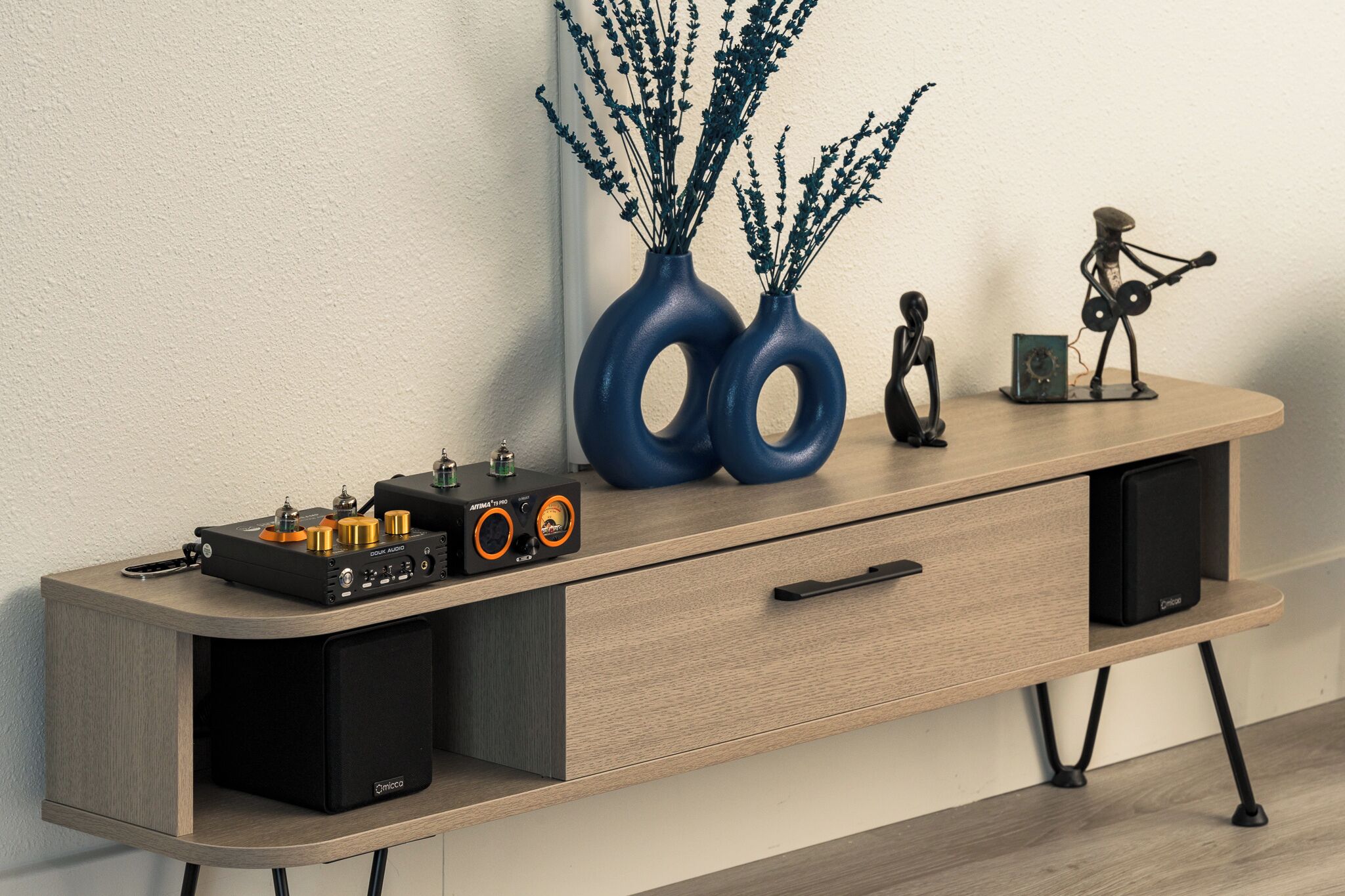 A wooden console table with a turntable, speakers, and decorative items.