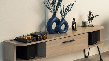 A wooden console table with a turntable, speakers, and decorative items.
