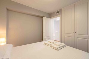 Ein Hotelzimmer mit einem Bett, einem Nachttisch, einer Lampe und einem Kleiderschrank.