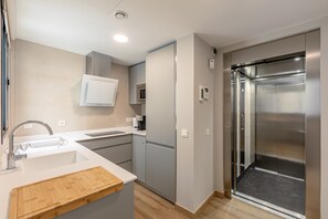 Eine moderne Küche mit Einbauofen, Kaffeemaschine und Edelstahl-Kühlschrank.