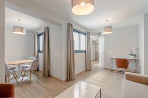 Ein modernes Hotelzimmer mit Essbereich, Sitzgelegenheit und Arbeitsplatz.