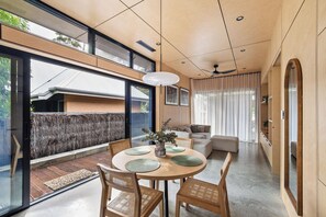 A modern interior with a dining area, sofas, and a view through large windows. - House Kayu - A unique home in the heart of Margaret River (Margaret River)