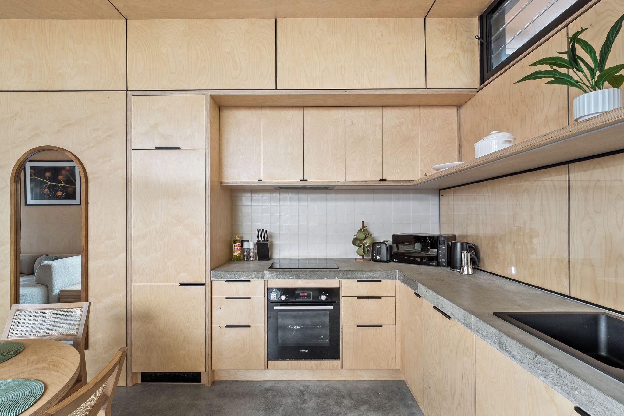 Eine kleine Küche mit Holzausstattung, einem Bosch-Ofen und modernen Geräten.