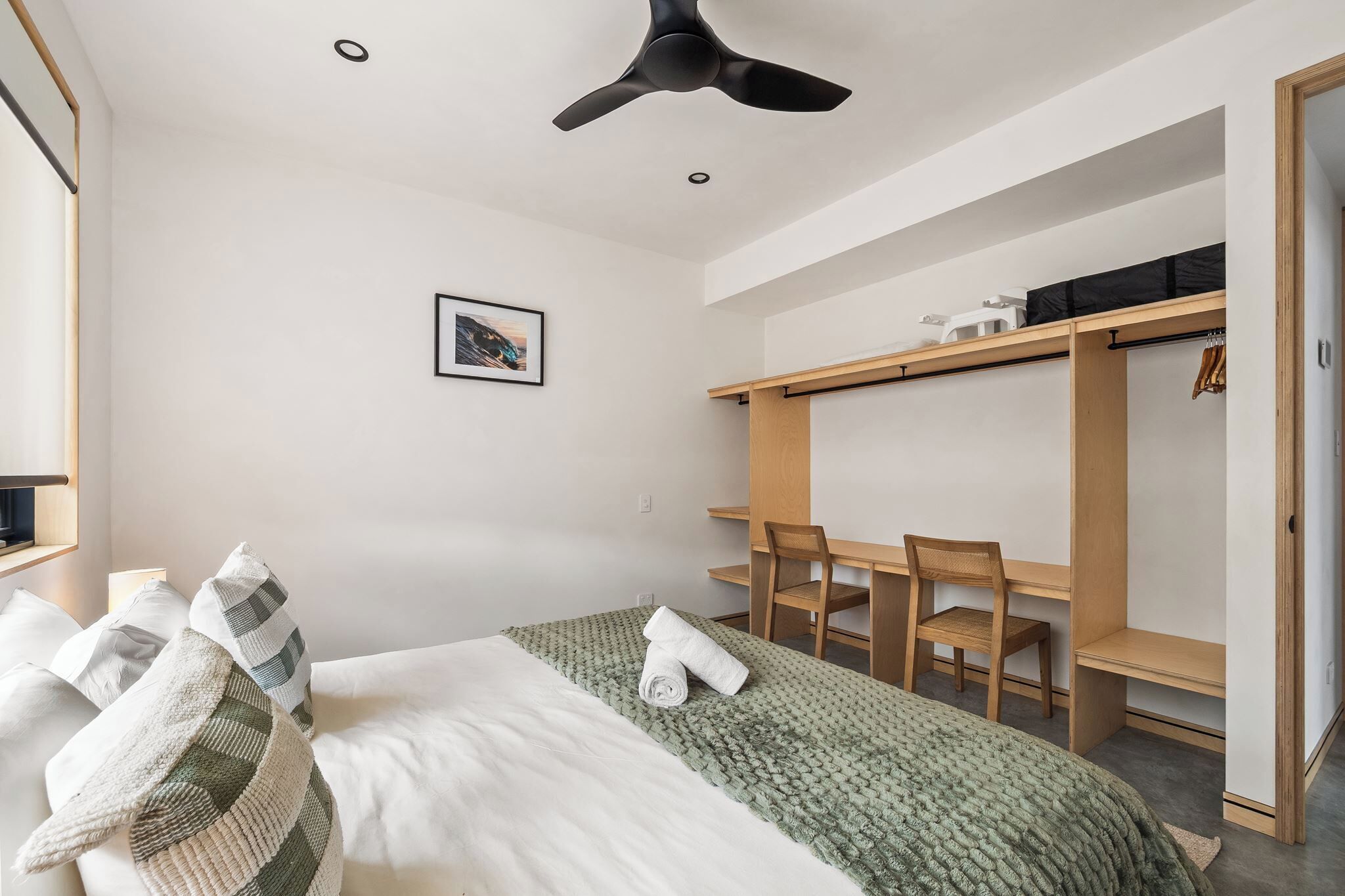 Une chambre à coucher avec un lit, un bureau et une armoire.