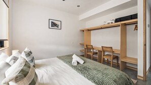 Ein Schlafzimmer mit Bett, Schreibtisch und Kleiderschrank.