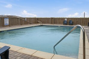 A rectangular pool with a wooden fence and a sign indicating pool rules and no diving. - Gulf Front • Pool • Beach Access • Sundunes 144 (Navarre)