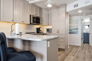 Een keuken met een marmeren aanrecht, roestvrijstalen apparatuur en een modern design.