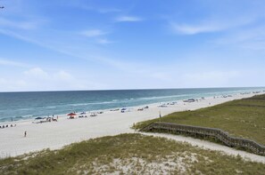 A beach with a wooden boardwalk leading to the shore, sandy beach, and the ocean. - Snowbirds Welcome • Gulf Front • Full Kitchen • Elevator • Sundunes 144 (Navarre)