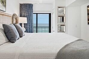 A hotel room with a large bed, a view of the sea, and a balcony. - Gulf Front • Pool • Beach Access • Sundunes 144 (Navarre)