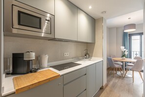 A modern kitchen with a built-in microwave, kettle, and coffee maker. - A2 Apartment with Cathedral Views – Historic Center of Seville and Pool (Seville)