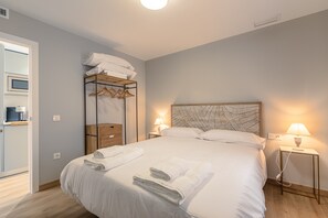 Ein Hotelzimmer mit einem Bett, einem Nachttisch mit Lampe, einem Kleiderschrank und einem Wandheizkörper.