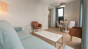 Una sala de estar moderna con un sofá, una mesa de centro y un comedor con sillas y una mesa.