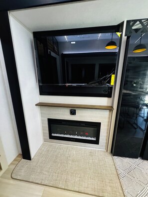 Ein modernes Wohnzimmer mit Flachbildfernseher über einem Kamin.